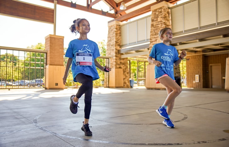 Girls on the Run participants run outside during program practice smiling